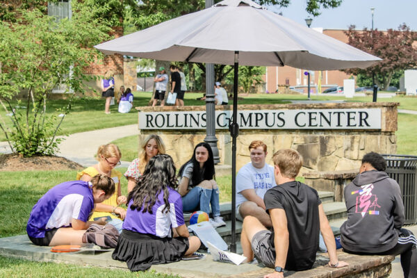 a group of people sitting under an umbrella