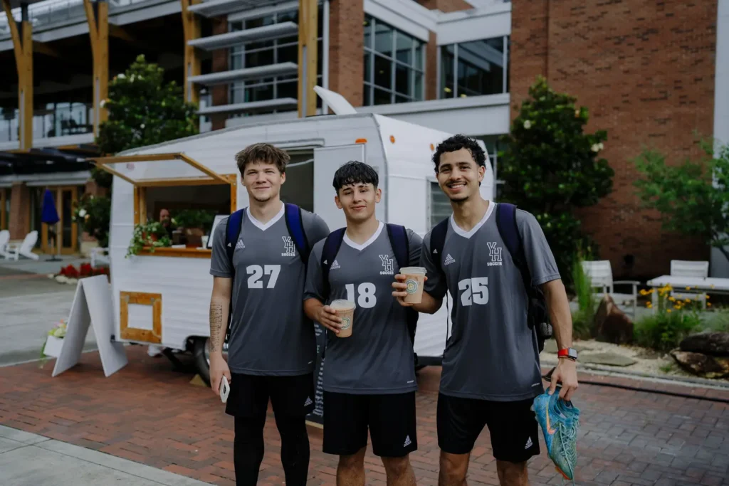 Three college athletes drinking coffee together